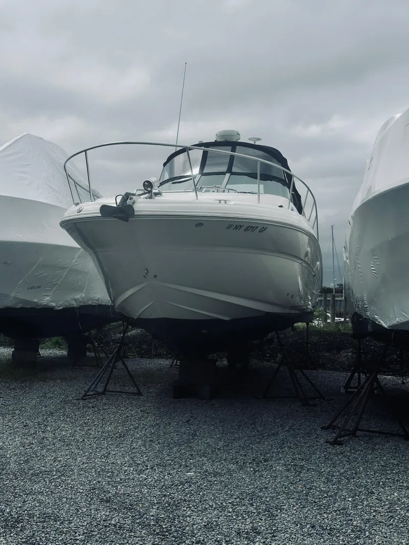 Slide: The Image of 2006 Sea Ray 320 Sundancer boat on stands, overcast sky background. - 5