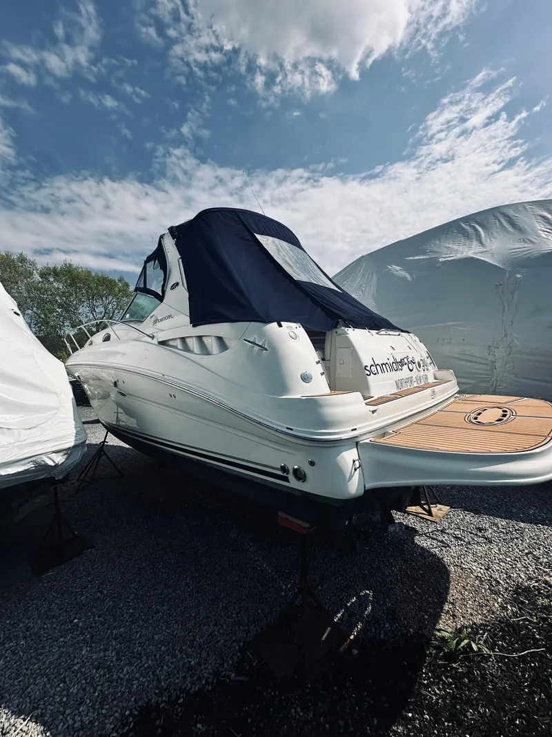 Slide: The Image of 2006 Sea Ray 320 Sundancer boat on gravel, under a partly cloudy sky. - 6