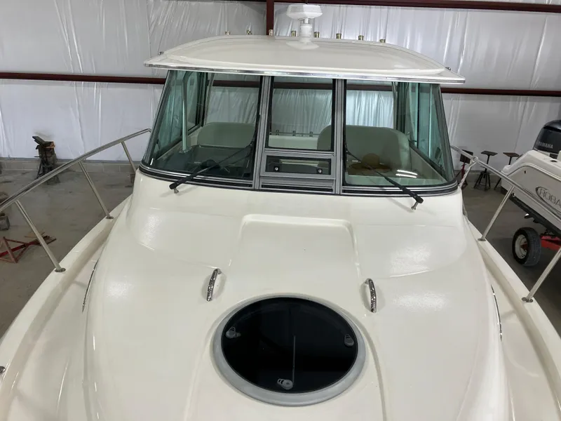 Slide: The Image of 2012 Striper 2901 Walkaround I/O boat in storage, showcasing front deck and cabin windows. - 14