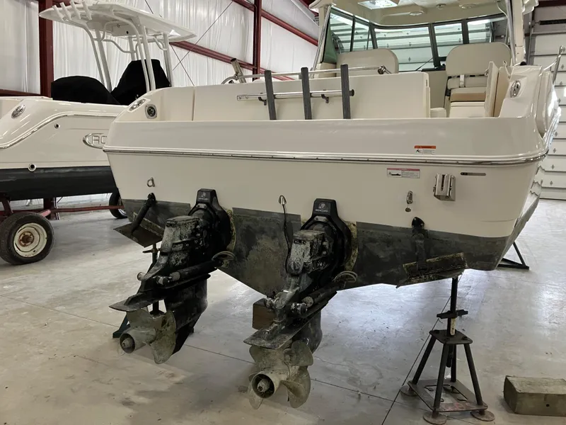 Slide: The Image of 2012 Striper 2901 Walkaround I/O boat in a storage facility, showing dual outboard engines. - 3