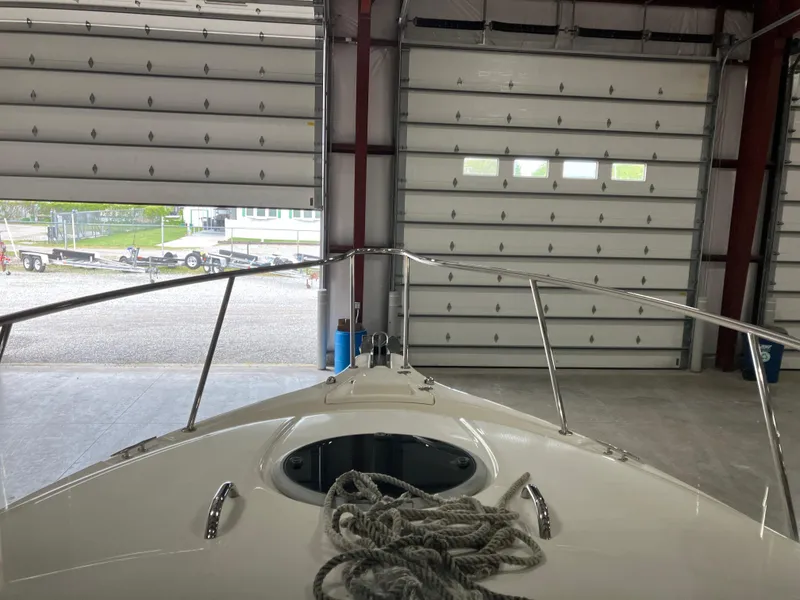 Slide: The Image of 2012 Striper 2901 Walkaround I/O boat in a garage with coiled rope on deck. - 34
