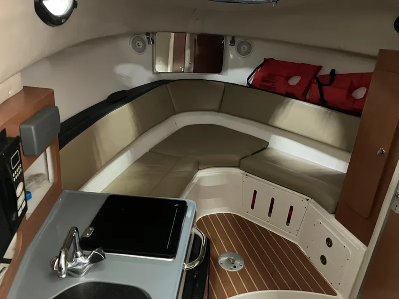 Slide: The Image of 2012 Striper 2901 Walkaround I/O cabin interior with seating, kitchenette, and life jackets. - 35