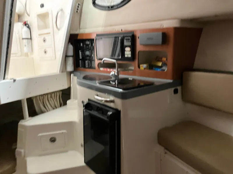 Slide: The Image of 2012 Striper 2901 Walkaround I/O boat interior with kitchenette and seating area. - 36