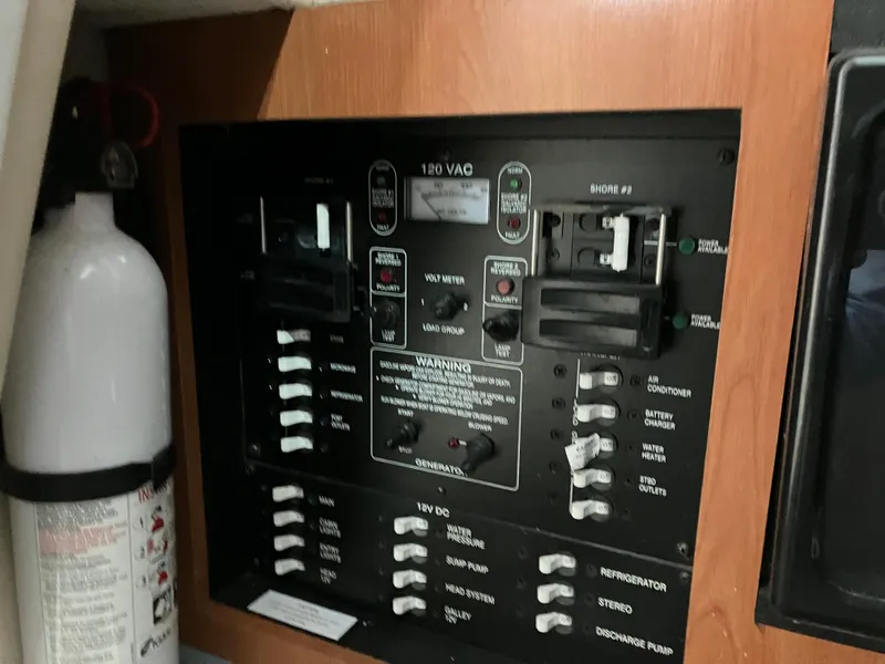 Slide: The Image of Electrical panel of 2012 Striper 2901 Walkaround I/O boat with fire extinguisher nearby. - 39
