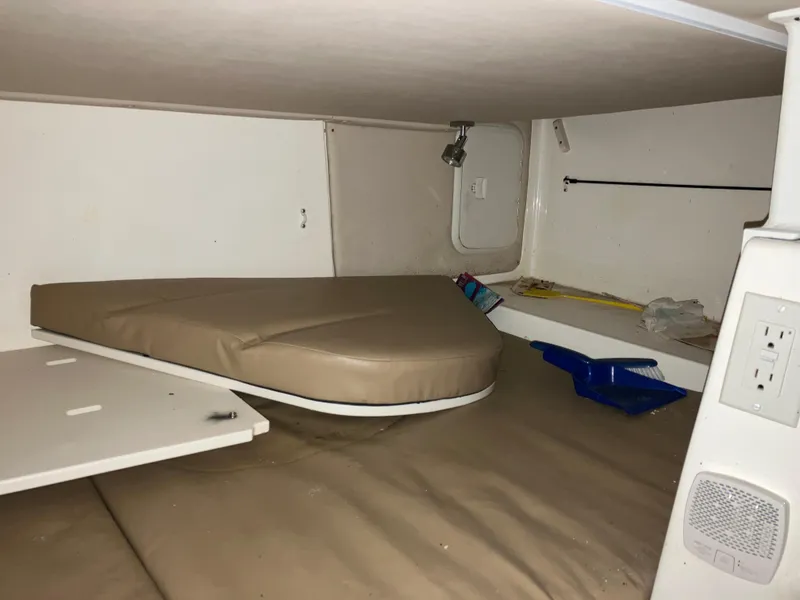 Slide: The Image of 2012 Striper 2901 Walkaround I/O cabin interior with beige cushions and storage space. - 41