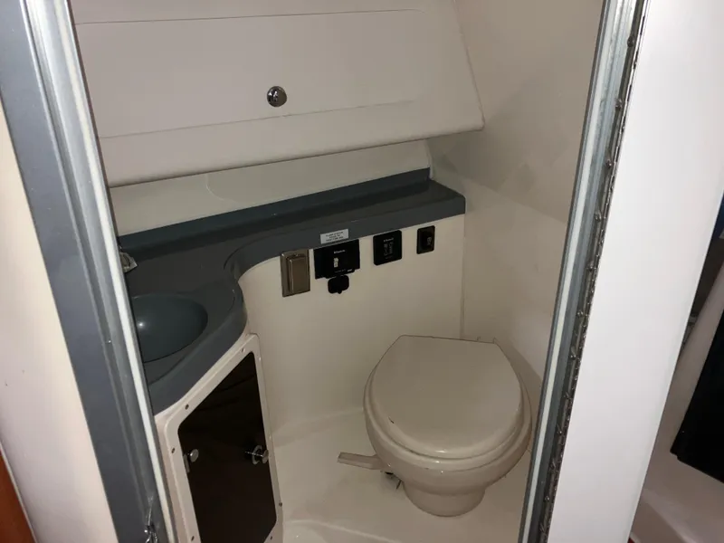 Slide: The Image of 2012 Striper 2901 Walkaround I/O boat bathroom interior with toilet and sink. - 44