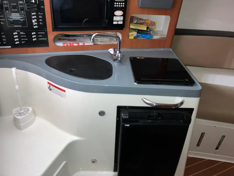 Slide: The Image of 2012 Striper 2901 Walkaround I/O boat interior with kitchenette, sink, and appliances. - 45