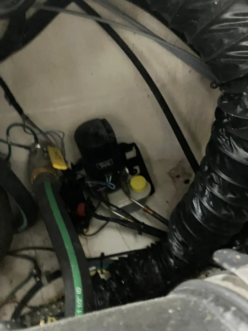 Slide: The Image of Engine compartment of a 2012 Striper 2901 Walkaround I/O boat, showing hoses and components. - 48