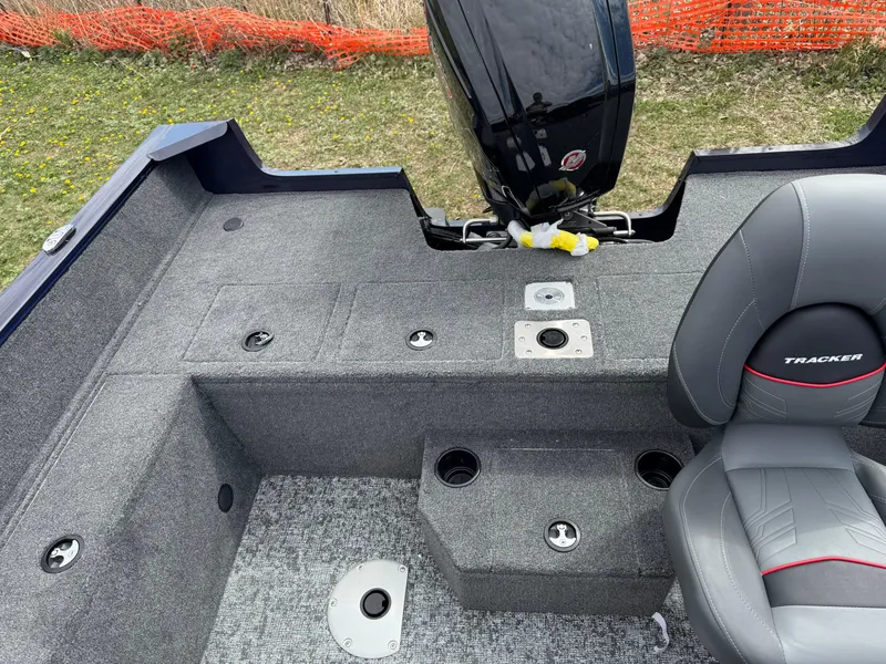 Slide: The Image of 2025 Tracker Pro Guide V-175 WT boat interior with seating and motor, on grassy background. - 12