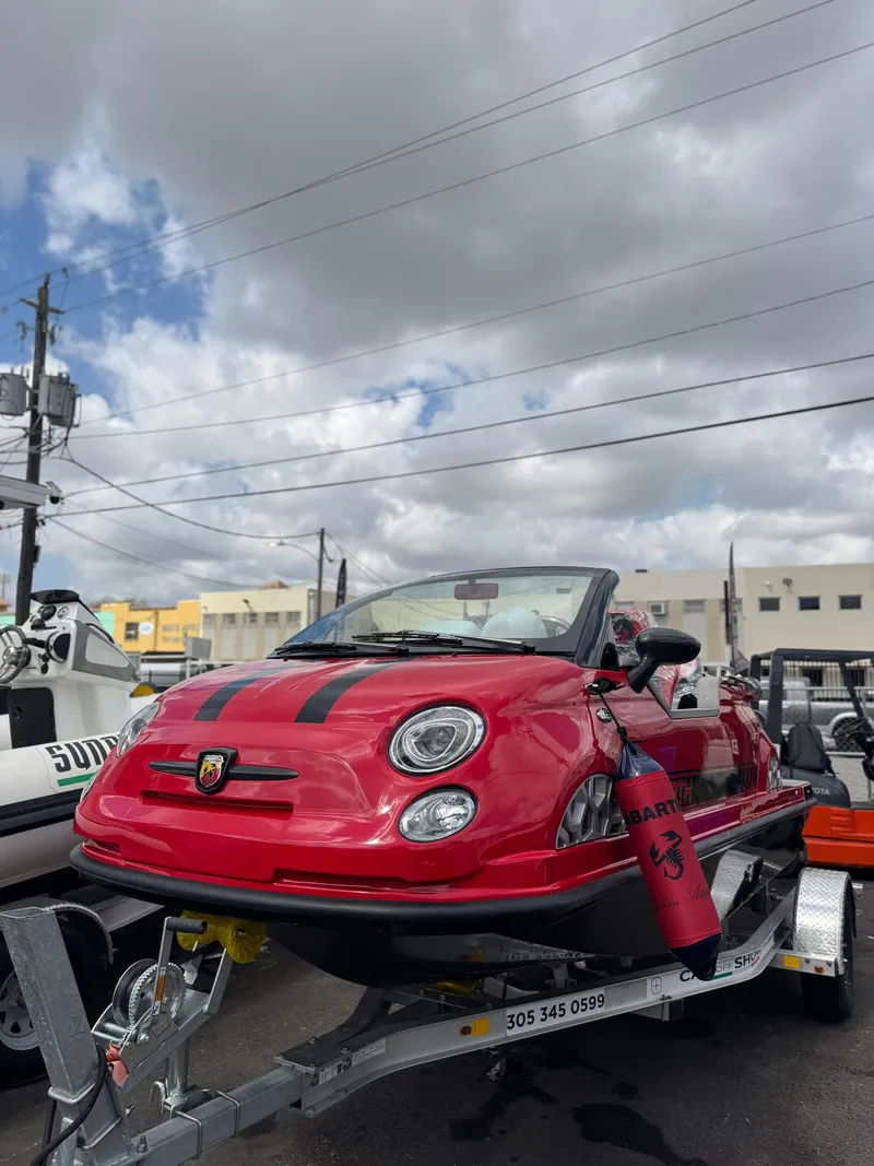 Slide: The Image of Red 2025 Car Off-shore Fiat 500 Abarth on trailer under cloudy sky. - 10