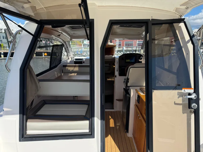 Slide: The Image of 2018 Cutwater C-242 Coupe interior with seating, wooden flooring, and open doors. - 10