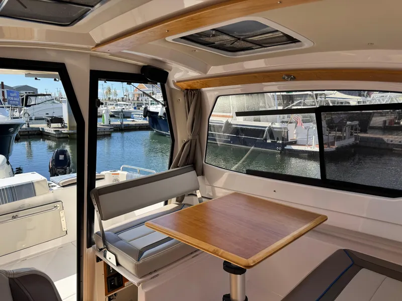 Slide: The Image of Interior of 2018 Cutwater C-242 Coupe boat with table and marina view. - 19