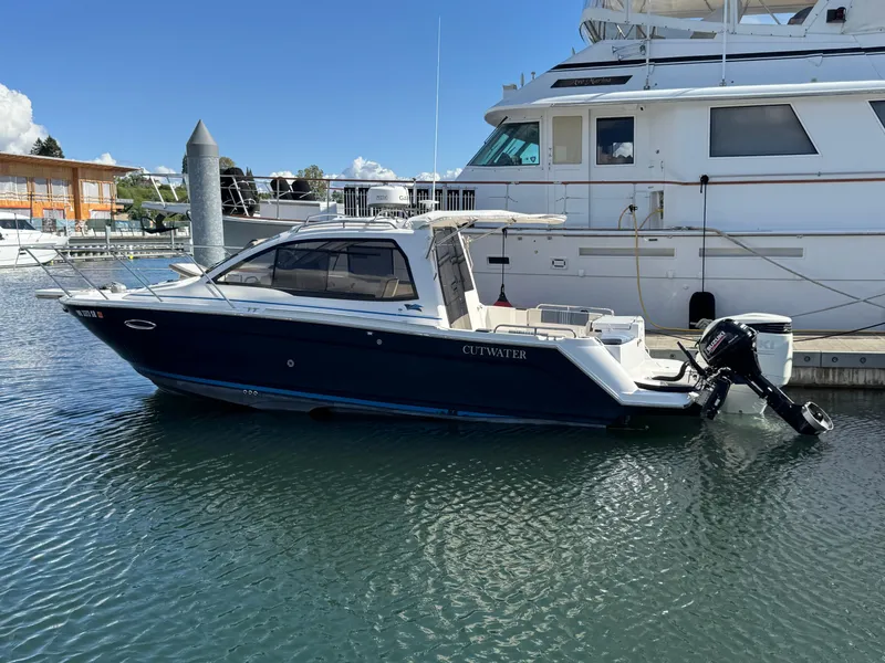Slide: The Image of 2018 Cutwater C-242 Coupe boat docked in marina, side view. - 2