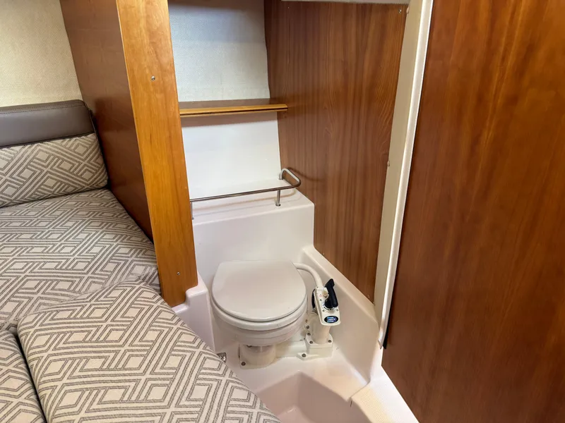 Slide: The Image of 2018 Cutwater C-242 Coupe interior with compact marine toilet and patterned bedding. - 22