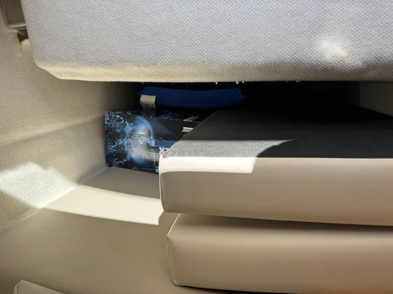 Slide: The Image of Interior storage area of a 2018 Cutwater C-242 Coupe boat with cushions and a box. - 27