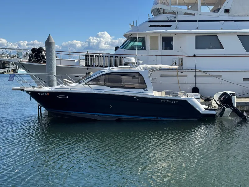 Slide: The Image of 2018 Cutwater C-242 Coupe boat docked in marina, calm water, clear sky. - 3