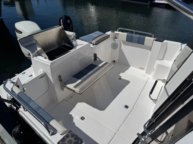 Slide: The Image of 2018 Cutwater C-242 Coupe boat interior with seating and grill, docked on water. - 9