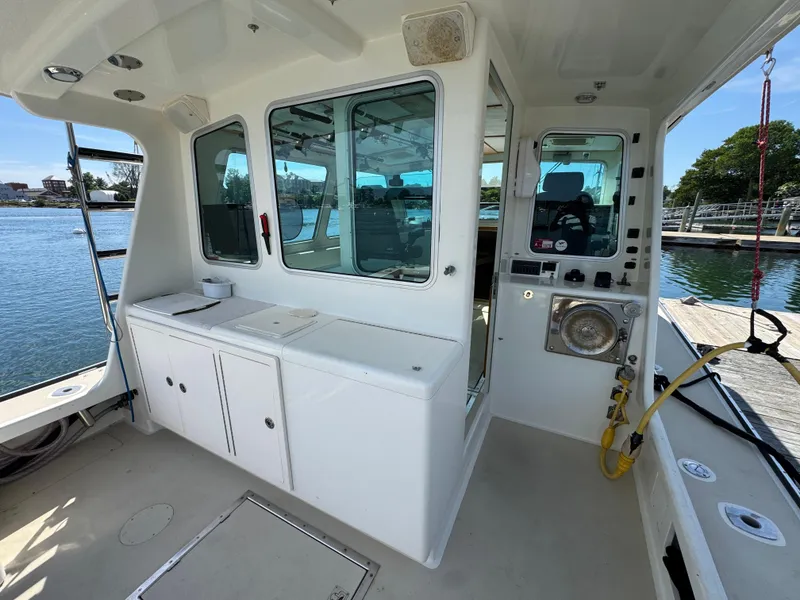 Slide: The Image of 2009 Northern Bay 36 boat interior with white cabinetry and windows, docked by the water. - 32