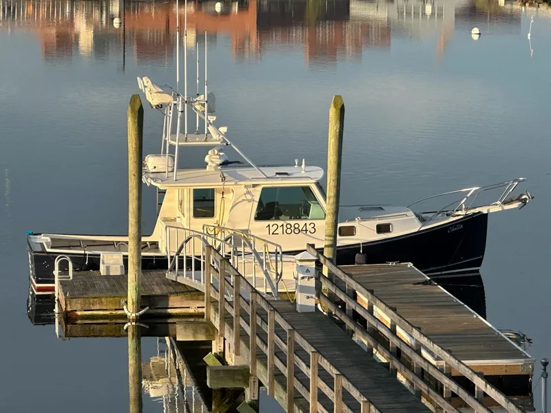 Slide: The Image of Northern Bay 36 boat docked at a calm marina, reflecting in the water, 2009 model. - 4