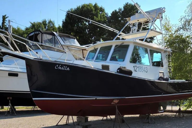 Slide: The Image of 2009 Northern Bay 36 boat on stands, named "Chilla," with trees in the background. - 5