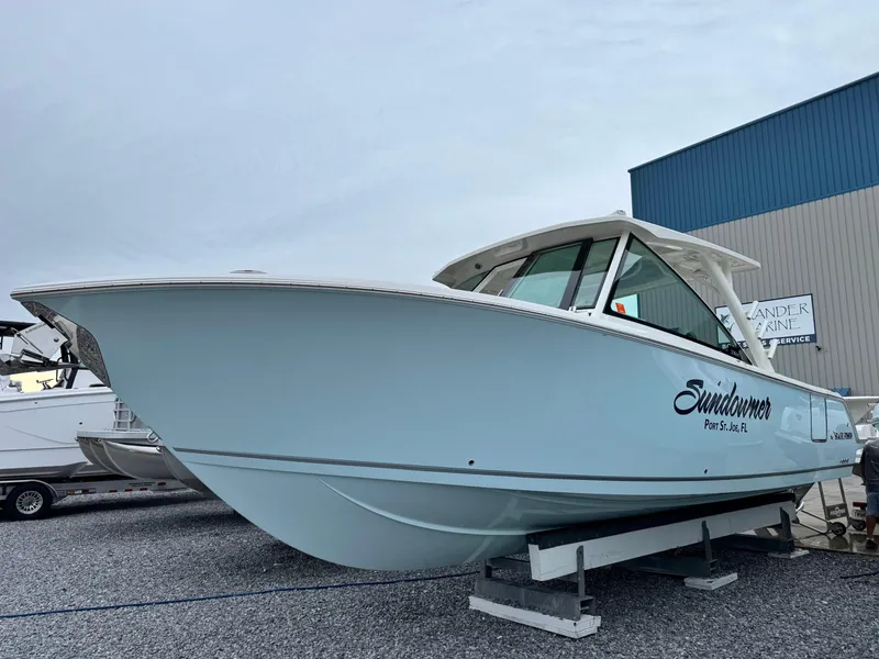 The Image of 2025 Sailfish 316 DC boat on display, light blue hull, parked on gravel. - 1