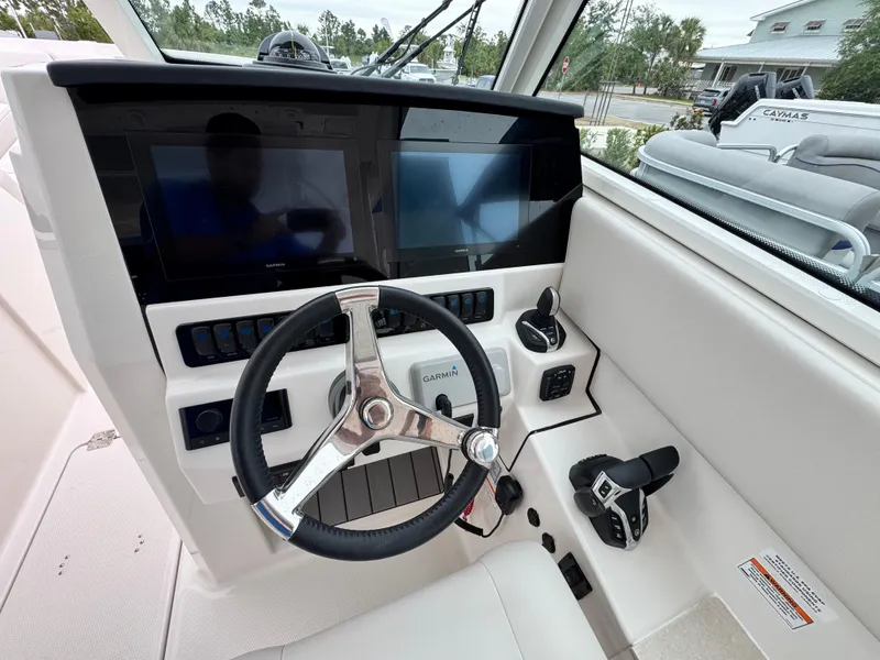 Slide: The Image of 2025 Sailfish 316 DC boat dashboard with dual screens and steering wheel. - 11