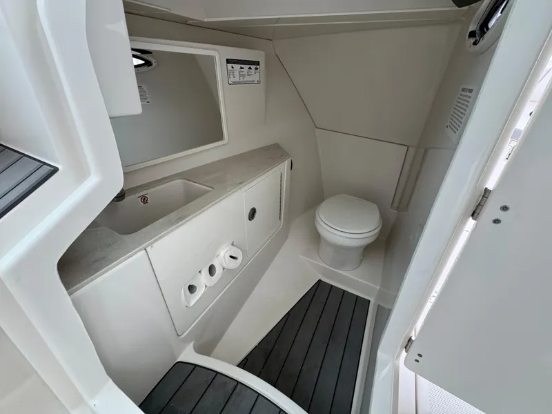Slide: The Image of 2025 Sailfish 316 DC boat interior with modern bathroom, featuring sink and toilet. - 14