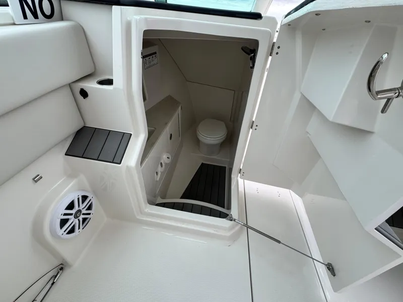 Slide: The Image of Interior view of 2025 Sailfish 316 DC boat's compact bathroom with toilet and speaker. - 15