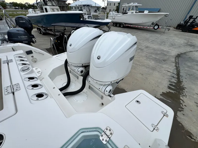 Slide: The Image of 2025 Sailfish 316 DC boat with dual outboard engines, docked in a marina. - 24