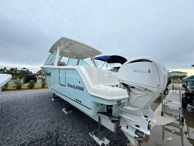 Slide: The Image of 2025 Sailfish 316 DC boat with Yamaha engines on display outdoors. - 6