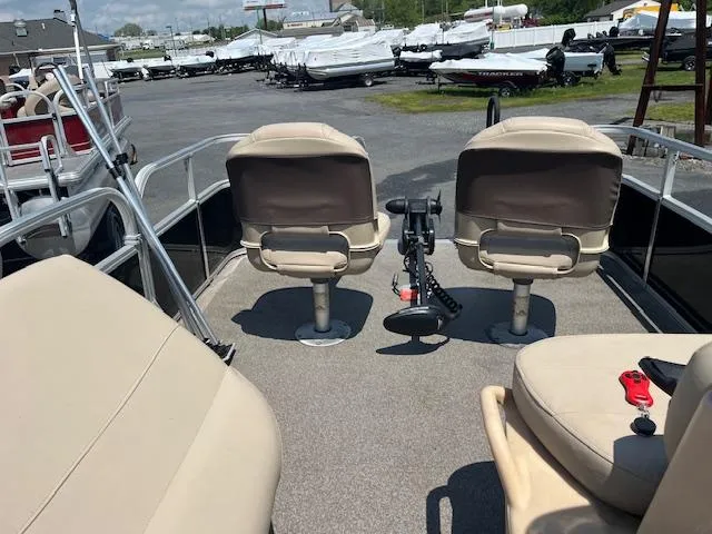 Slide: The Image of 2018 Sun Tracker Bass Buggy 16 DLX pontoon boat with beige seating in a marina. - 5