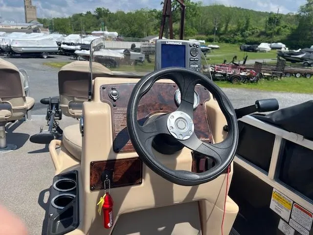 Slide: The Image of 2018 Sun Tracker Bass Buggy 16 DLX steering console with Lowrance fishfinder, cup holders, and key. - 7