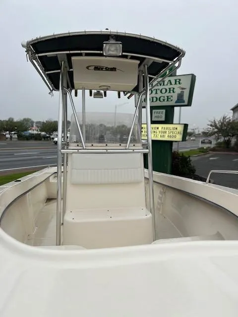 Slide: The Image of 2007 May-Craft 2300CC boat with T-top, parked near a motor lodge. - 2