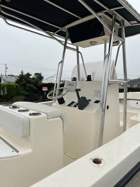 Slide: The Image of 2007 May-Craft 2300CC boat with center console and T-top, docked outdoors. - 4
