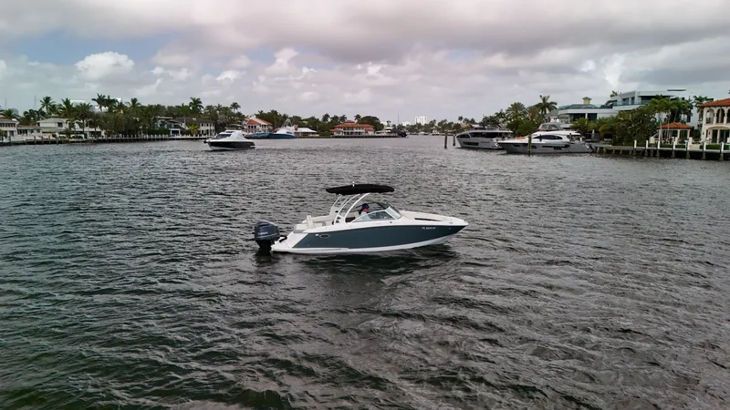 Slide: The Image of 2021 Cobalt 25SC boat on a scenic waterway with luxury homes and yachts. - 10