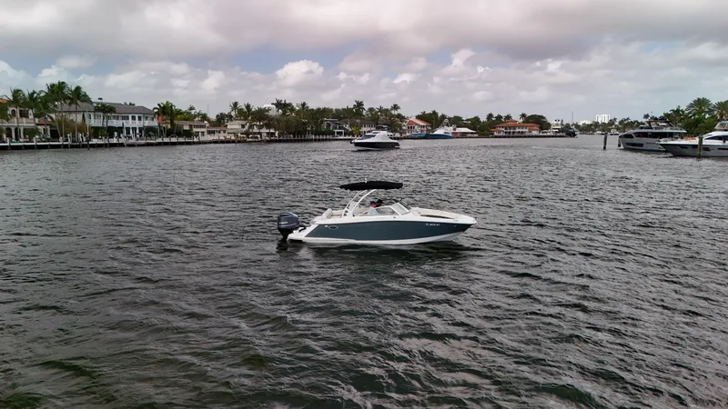 Slide: The Image of 2021 Cobalt 25SC boat on a scenic waterfront with houses and palm trees. - 11