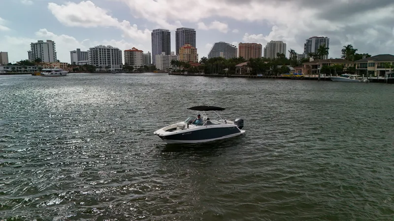 Slide: The Image of 2021 Cobalt 25SC boat on water with city skyline in background. - 15