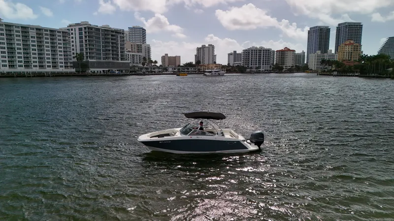 Slide: The Image of 2021 Cobalt 25SC boat on water with city skyline in background. - 16