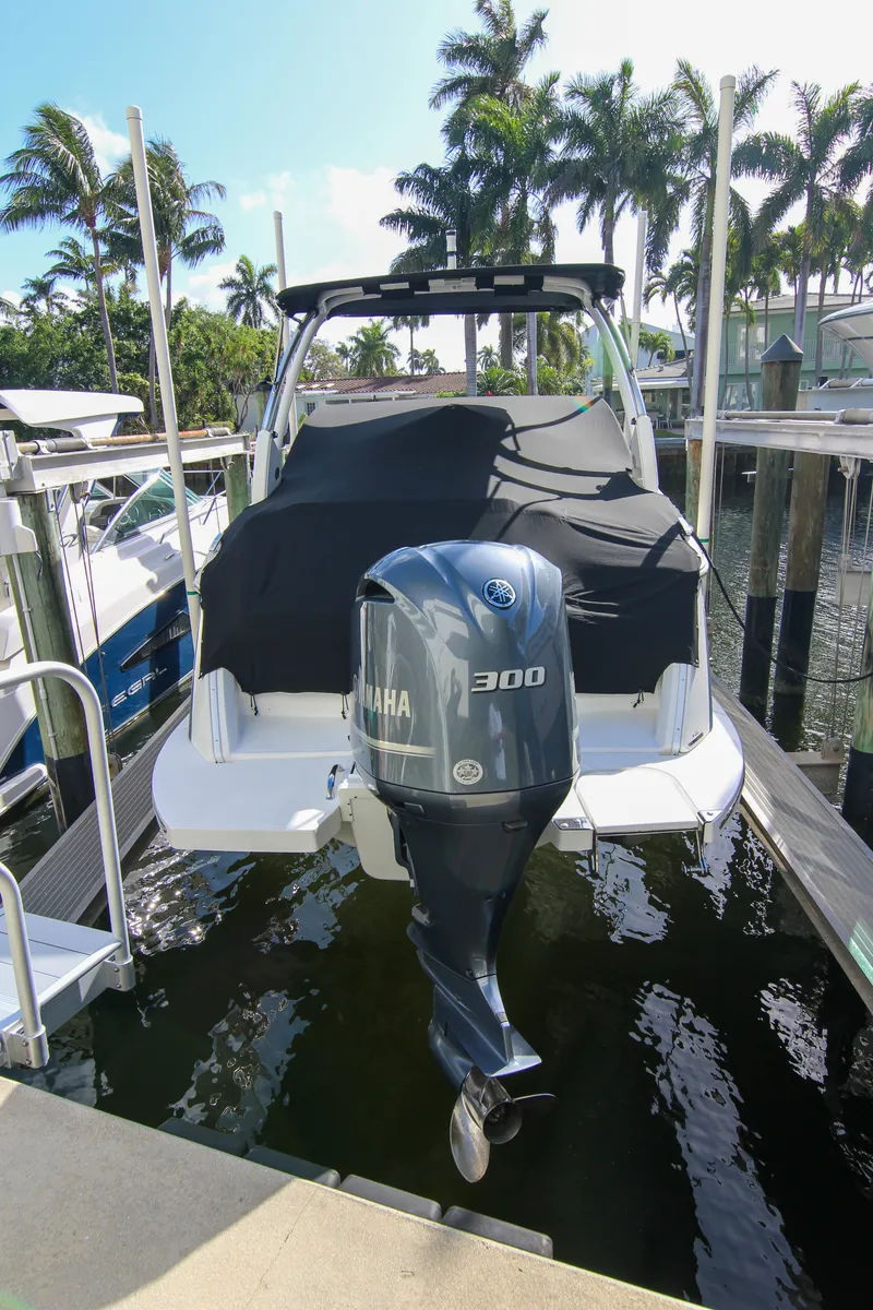 Slide: The Image of 2021 Cobalt 25SC boat with Yamaha 300 engine docked near palm trees. - 25