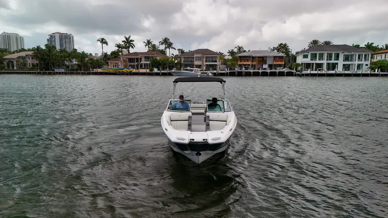 Slide: The Image of 2021 Cobalt 25SC boat cruising on a scenic waterfront with luxury homes in the background. - 3