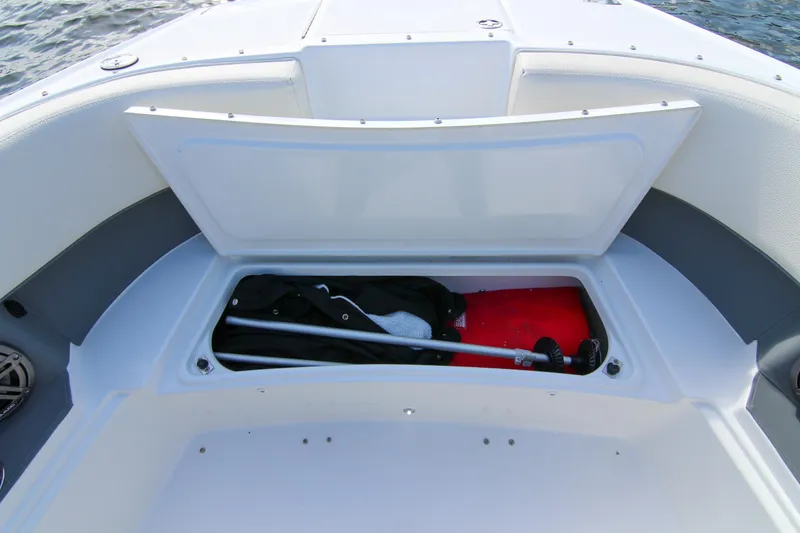 Slide: The Image of Open storage compartment on 2021 Cobalt 25SC boat, containing equipment and gear. - 30
