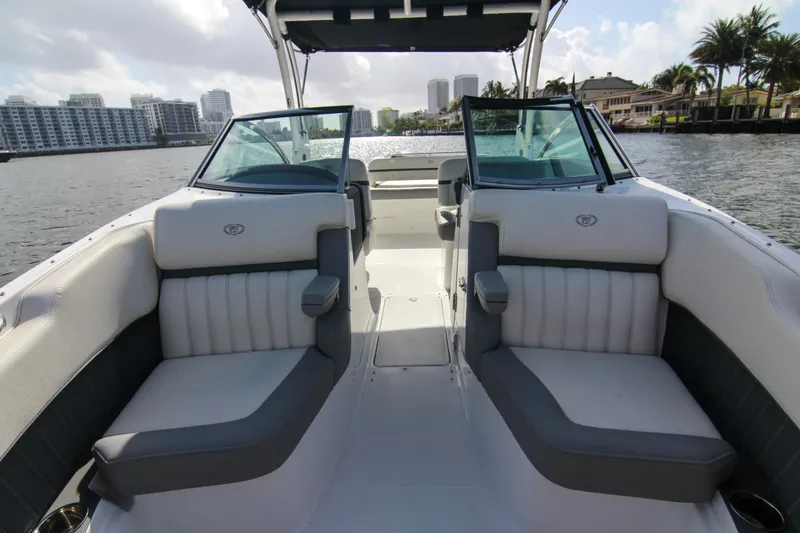 Slide: The Image of 2021 Cobalt 25SC boat interior with plush seating on a sunny waterfront. - 33