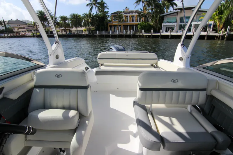 Slide: The Image of 2021 Cobalt 25SC boat interior with luxurious seating, docked by waterfront homes. - 37