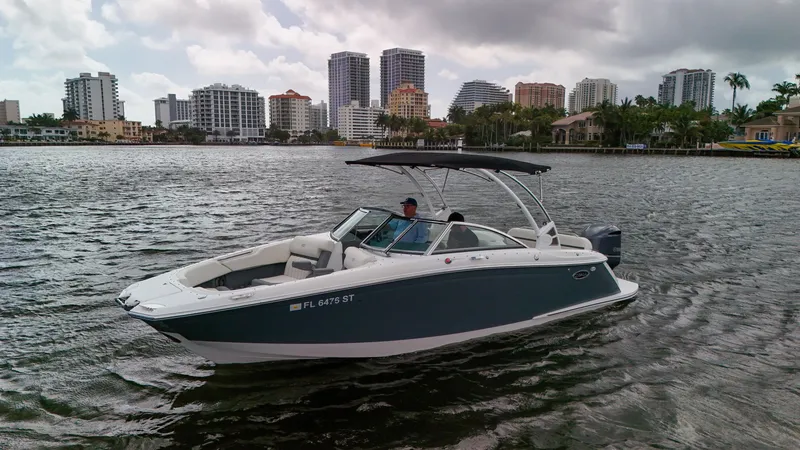 Slide: The Image of 2021 Cobalt 25SC boat cruising on a city waterfront with skyscrapers in the background. - 4