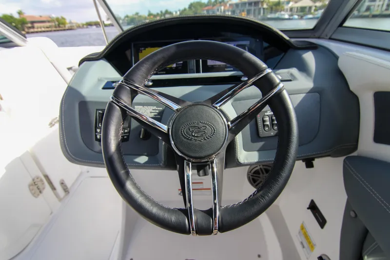Slide: The Image of Steering wheel of a 2021 Cobalt 25SC boat, featuring a sleek, modern dashboard design. - 42