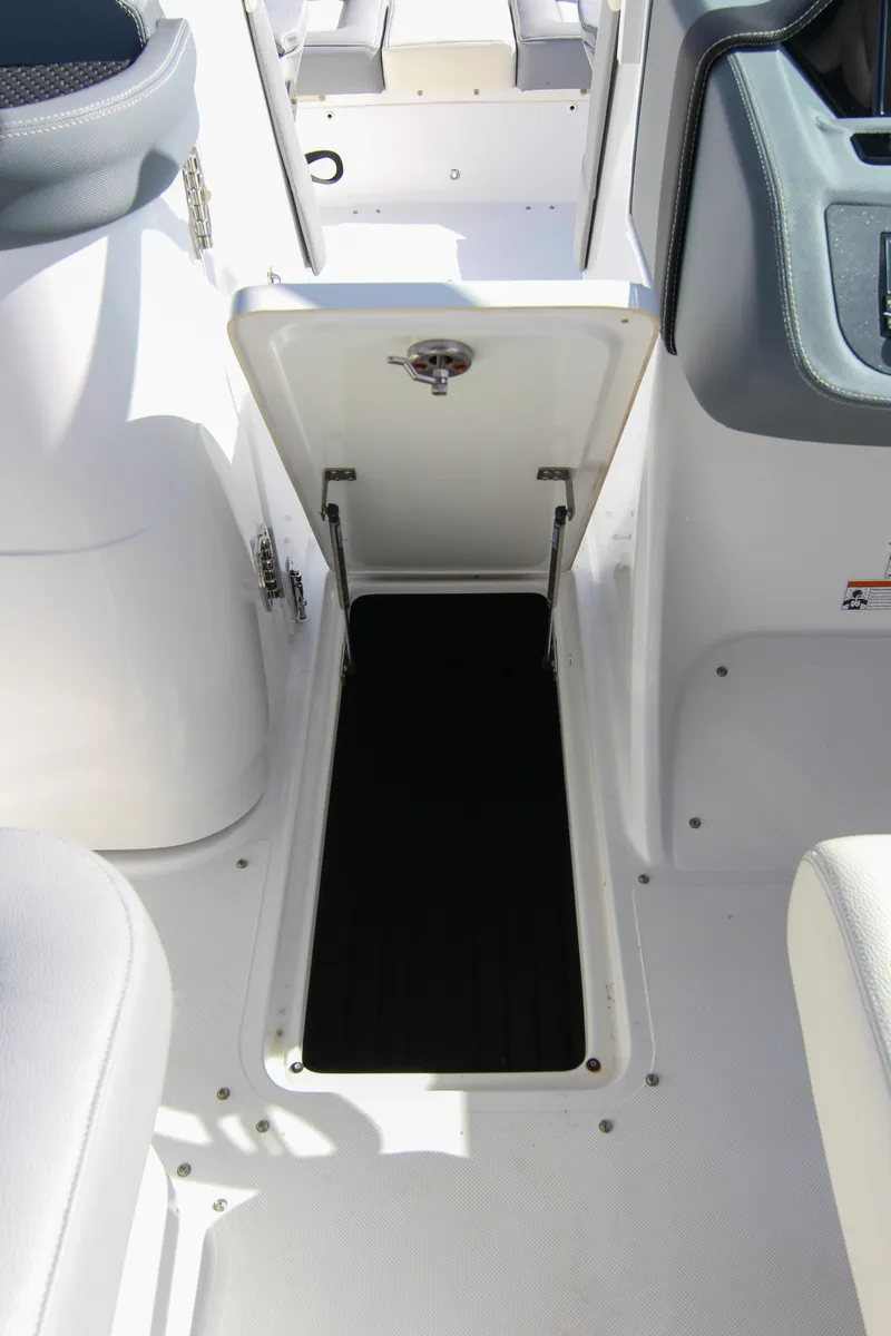 Slide: The Image of 2021 Cobalt 25SC boat storage compartment with open hatch, showcasing interior space. - 47