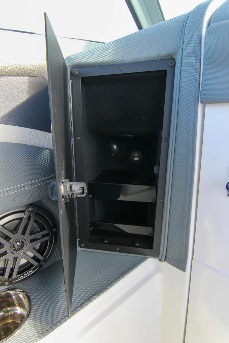 Slide: The Image of 2021 Cobalt 25SC boat storage compartment with speaker and cup holder. - 48