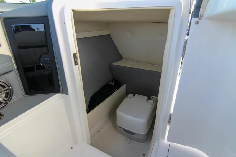 Slide: The Image of 2021 Cobalt 25SC boat interior with compact marine toilet and storage space. - 49