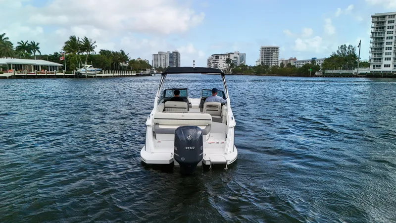 Slide: The Image of 2021 Cobalt 25SC boat cruising on a scenic waterway with city skyline. - 7