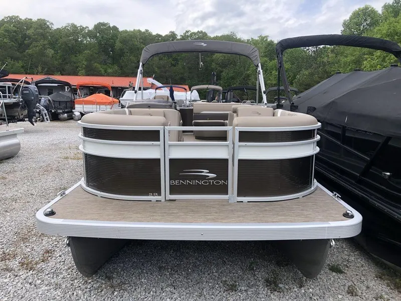 Slide: The Image of 2023 Bennington 21 SXL pontoon boat displayed outdoors on gravel. - 3